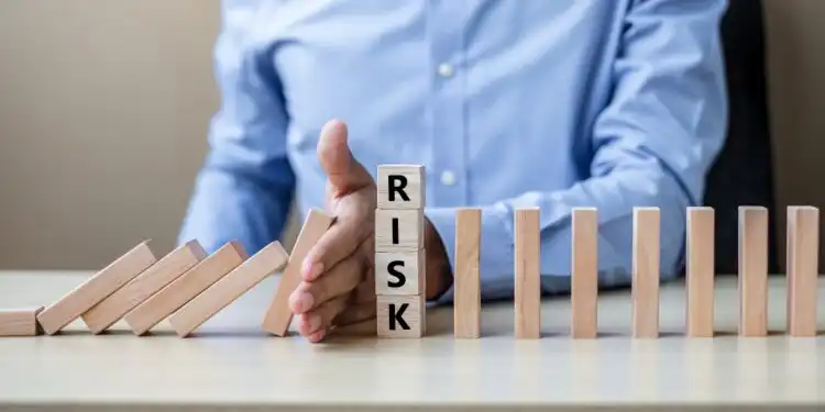 businessman-hand-stopping-falling-wooden-blocks-dominoes - Pratama Institute