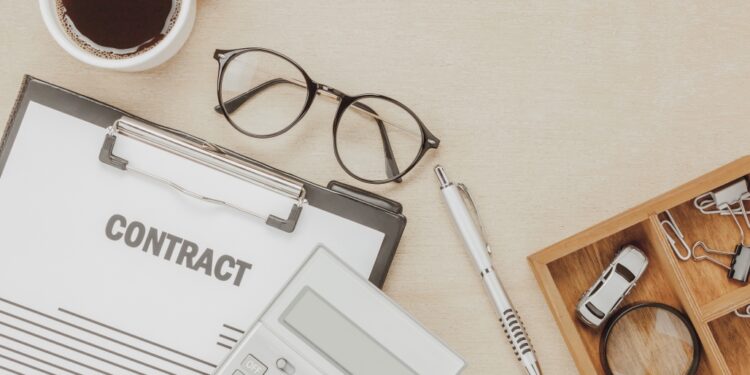 top-view-business-contract-form-with-coffee-eyeglasses-car-calculator-pen-with-magnifying-glass-wooden-background - Pratama Institute perjanjian pranikah