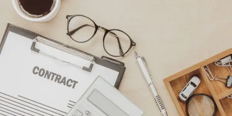 top-view-business-contract-form-with-coffee-eyeglasses-car-calculator-pen-with-magnifying-glass-wooden-background - Pratama Institute perjanjian pranikah