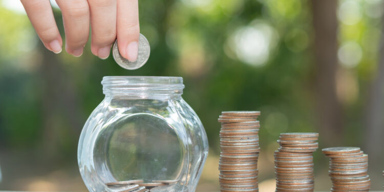 Saving money concept preset by Male hand putting money coin stac - Pratama Institute deposit