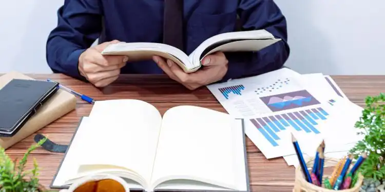 businessman-reading-book-seats-their-desks_10221-9652 - Pratama Institute #image_title