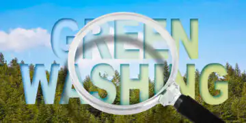Alert to Greenwashing - concept with text against a woodland and magnifying glass