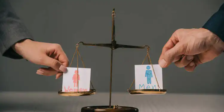 stock-photo-cropped-view-businesspeople-male-female-signs-scales-justice-gender-equality - Pratama Institute #image_title
