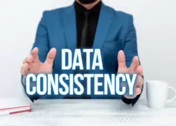 Business professional in a blue suit framing glowing 'DATA CONSISTENCY' text to emphasize the concept of data integrity/consistency.