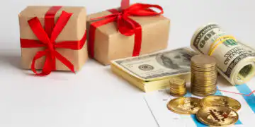 Two gift boxes with red ribbons beside rolled cash, coins, and a financial chart.