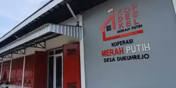 Exterior of a cooperative building with red doors and a large sign reading Koperasi Merah Putih Desa Dukuhrejo