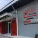 Exterior of a cooperative building with red doors and a large sign reading Koperasi Merah Putih Desa Dukuhrejo
