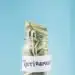 Jar filled with folded dollar bills labeled 'RETIREMENT' against a blue background, symbolizing retirement savings.