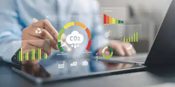 Hands over a tablet with floating CO2 analytics: charts and icons about emissions and sustainability.