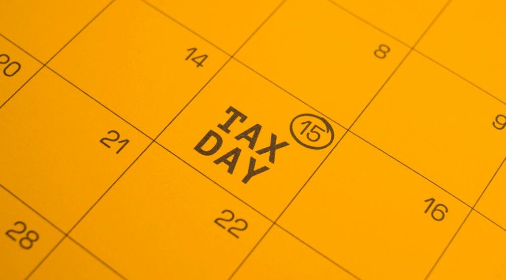 Calendar page highlighting TAX DAY on the 15th with a circled 15 mark in a yellow page theme.