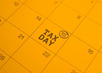 Calendar page highlighting TAX DAY on the 15th with a circled 15 mark in a yellow page theme.