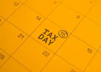 Calendar page highlighting TAX DAY on the 15th with a circled 15 mark in a yellow page theme.